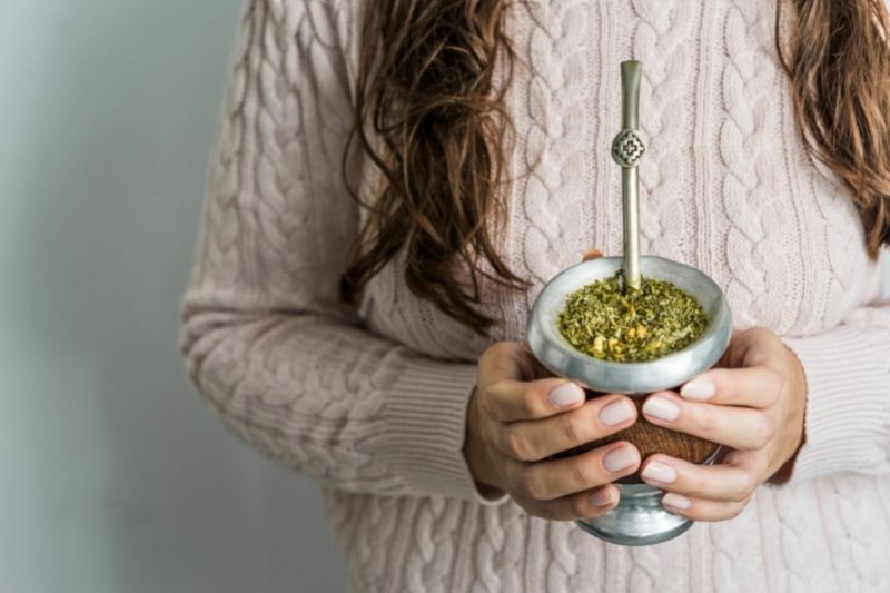 Kobieta trzymająca w dłoniach przygotowany napój z yerba mate