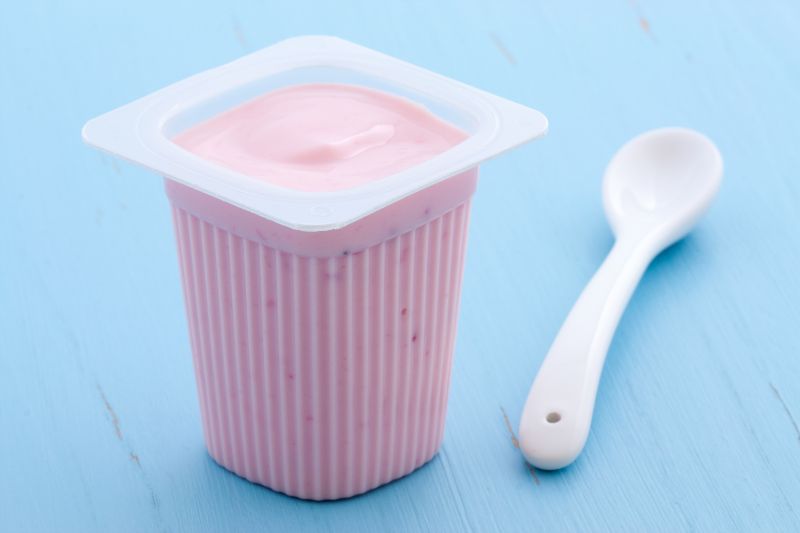 Zbliżenie na różowy jogurt na niebieskim tle