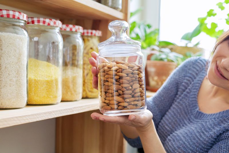 Migdały przechowywane w szklanym słoiku dekoracyjnym obok innych produktów
