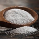 kwasek cytrynowy wysypujący się z drewnianej łyżki